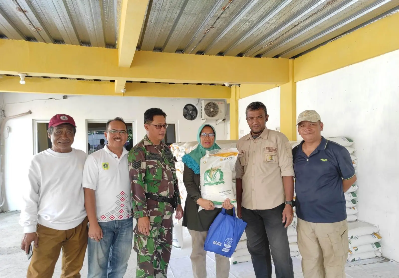 Petugas Kawal Antrian Warga Penerima Bantuan Beras Desa Cimandala
