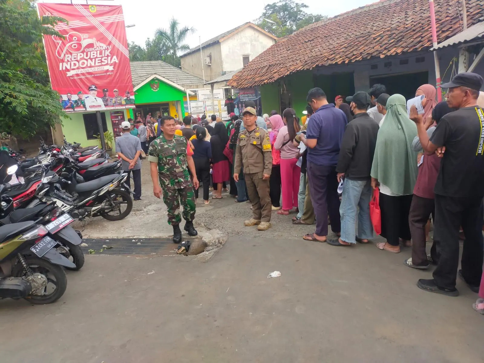 Antrian Warga Penerima Bantuan Pangan Cilebut Timur Dikawal Petugas